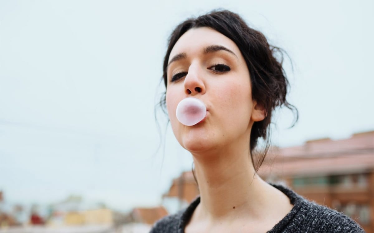 a woman blowing bubble gum