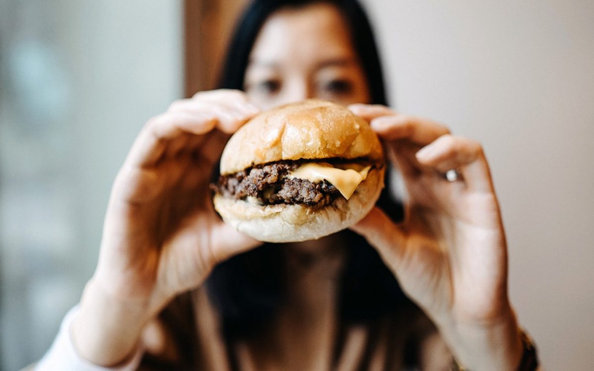 woman holding cheeseburger