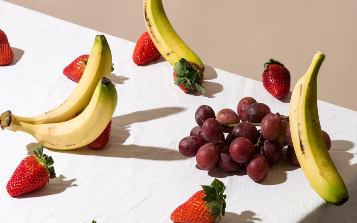 bananas, strawberries, and grapes on a tablecloth