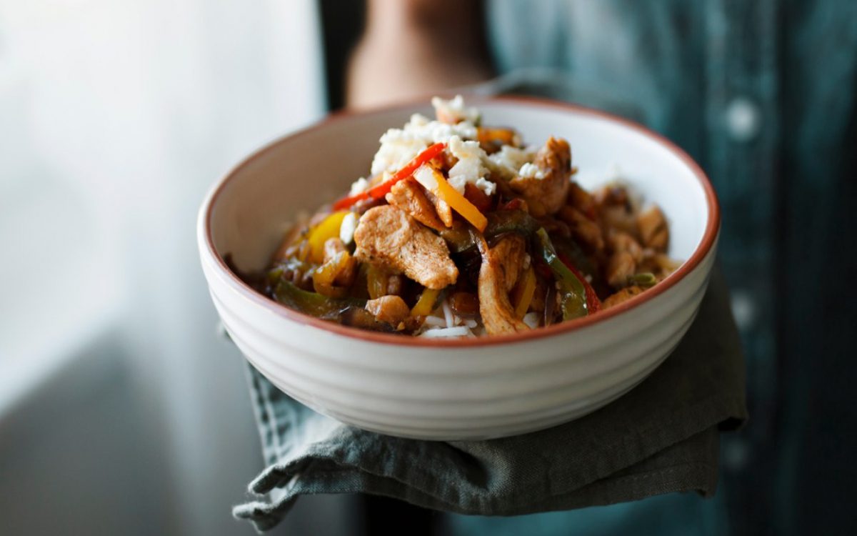 stir fry with rice, chicken, and peppers in a bowl