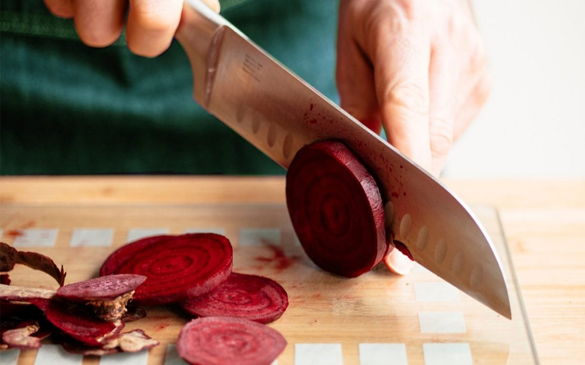 slicing raw beets on cutting board