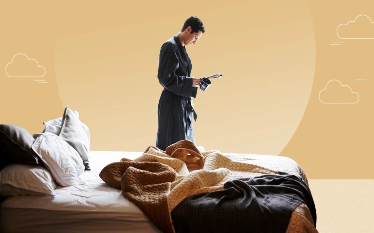 Person standing near king size mattress and reading a newspaper